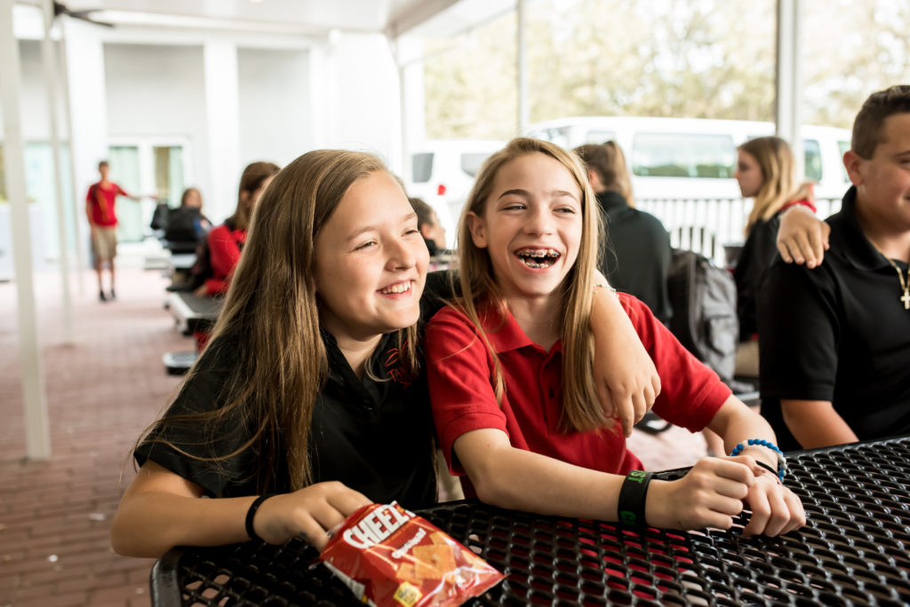 Two female students laughing during break at school.